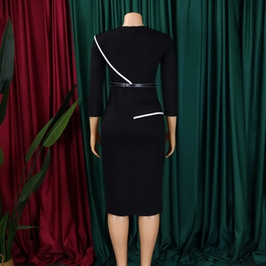 Detail of elegant black sheath dress with white diagonal accents and thin waist belt
