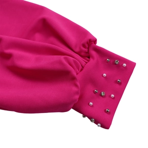 Dettaglio ravvicinato del polsino della tuta rosa con perline e strass scintillanti fatti a mano