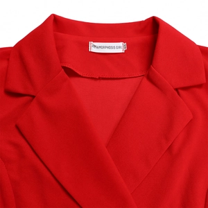 Detail van rode blazer kraag op een geplooide jurk met hoogwaardige geweven textuur