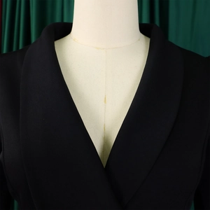 Detail of elegant black shawl collar blazer featuring premium woven fabric on a mannequin