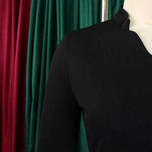 Detail of high collar and shoulder seam on black flare sleeve top with matte fabric