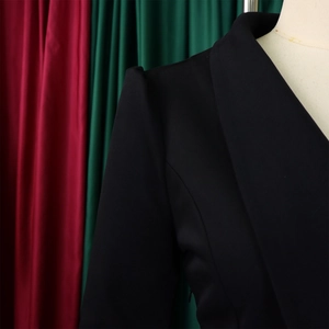 Detail of elegant black blouse shoulder with crisp pleated tailoring and matte texture