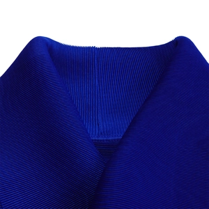 Dettaglio del tessuto plissettato blu reale con elegante scollo a V e trama plissé fine