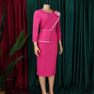 Detail of rose pink pencil dress featuring 3D floral accent and asymmetrical white trim