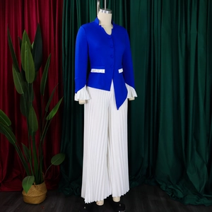 Detail of royal blue top with bell sleeves and white pleated wide-leg trousers