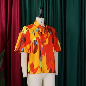 Détail de l'imprimé abstrait coloré avec col à nœud et manches bouffantes élégantes