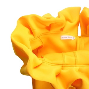 Dettaglio dello scollo dell'abito da sera giallo con volant e rifiniture di cucitura