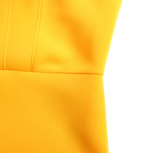 Dettaglio macro delle cuciture di qualità sul tessuto giallo di un abito da sera lungo