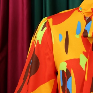 Détail de la blouse imprimée abstraite montrant le col montant et les manches bouffantes