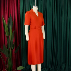 Détail d'une robe midi plissée col en V rouge orangé avec ceinture à boucle assortie