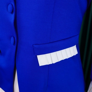 Detailed macro view of royal blue jacket with fabric buttons and white pleated pocket trim