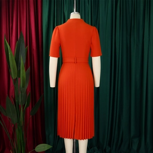 Détails de l'ourlet plissé et de la taille de cette élégante robe orange à manches courtes