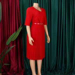 Détail de la robe rouge à col en V avec jupe plissée et ceinture assortie sur un mannequin