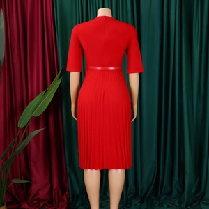 Détail du dos d'une robe rouge plissée à col en V avec fermeture éclair et ceinture fine