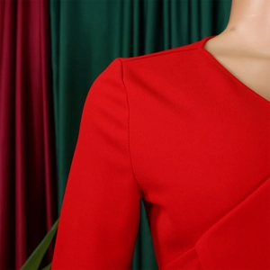 Détail de robe rouge à col en V avec décolleté plissé asymétrique et manches longues