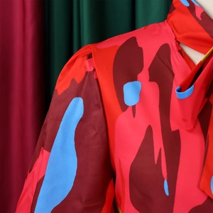 Détail d'un chemisier en soie avec col montant et motif géométrique coloré