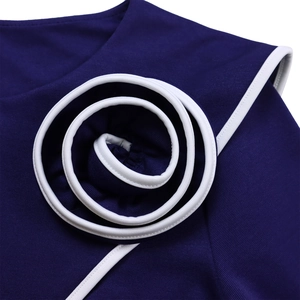 Close-up of a navy pencil dress featuring 3D spiral flower detail and white piping trim