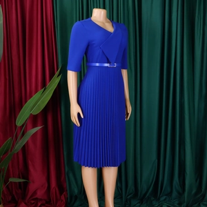 Gros plan d'une robe bleue royale à col en V avec des plis fins et une boucle dorée