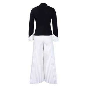 Detail view of bell sleeves and pleated wide-leg pants on black and white outfit