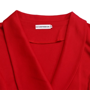 Detail view of red blazer collar with white woven label showing size M and fabric texture