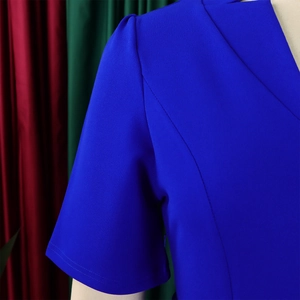 Gros plan sur la robe bleue à col en V avec manches plissées et texture de crêpe fine