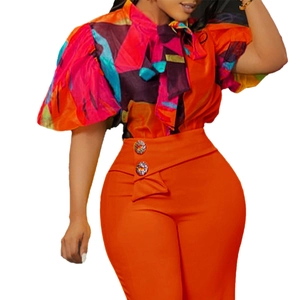 Détail du pantalon orange taille haute avec boucles en strass et fronces à la taille