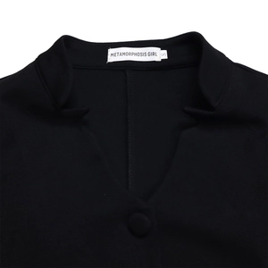 Detail of V-neckline with fabric-covered button on black knit flare sleeve top