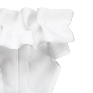 Dettaglio dell'abito bianco con spalle scoperte, balze a strati e tessuto a maglia