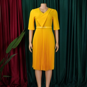 Détail d'une robe plissée élégante jaune avec col en V et ceinture assortie à la taille