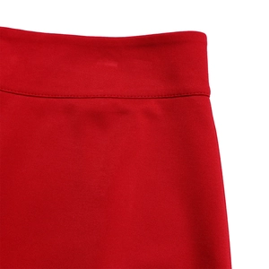 Detail of red wide-leg trousers showing high-quality stitching and textured fabric