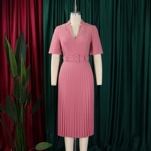 Détail d'une robe rose col en V avec ourlet plissé et ceinture à boucle carrée assortie