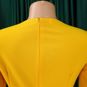 Détail de la fermeture éclair invisible au dos d'une robe plissée jaune vif à col V