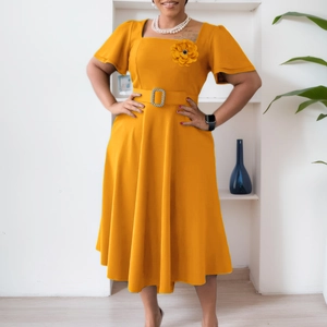Detail of a bright yellow midi dress featuring a square neckline and 3D floral accent