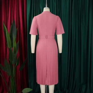 Vue détaillée du dos d'une robe rose plissée à manches courtes avec ceinture élégante