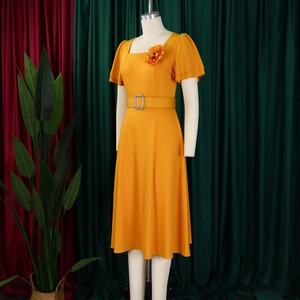 Detail of square neckline with 3D flower and belted waist on yellow summer dress