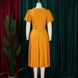 Detail view of mustard yellow dress featuring invisible back zipper and waist belt