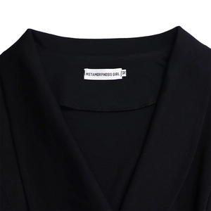 Detail of V-neck collar with brand label and size M on black fabric of the elegant suit