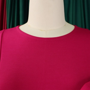 Close-up of the elegant round neckline and textured fuchsia fabric of the dress
