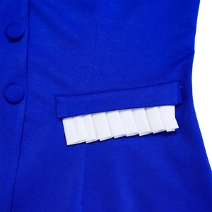 Macro shot of royal blue fabric featuring a pocket with white pleated trim and buttons