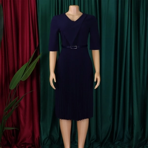 Détail d'une robe bleu marine à col en V avec jupe plissée et ceinture fine
