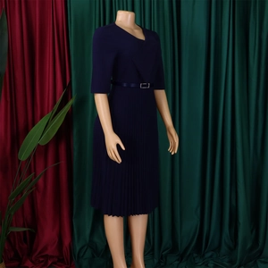 Détail d'une robe plissée bleu marine avec décolleté en V asymétrique et taille ceinturée