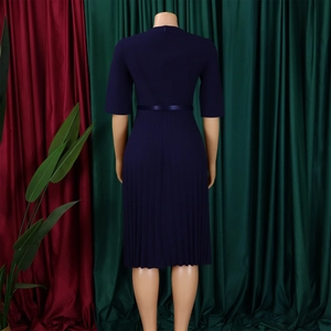 Vue arrière d'une robe mi-longue plissée bleu marine avec manches et ceinture nouée