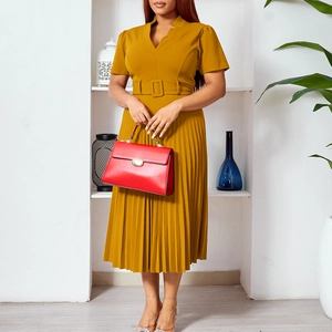 Détail d'une robe plissée jaune moutarde avec col en V et ceinture assortie pour la taille