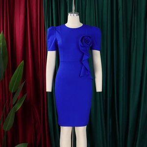 Detail of royal blue dress featuring a 3D rose decoration and elegant ruffle accents
