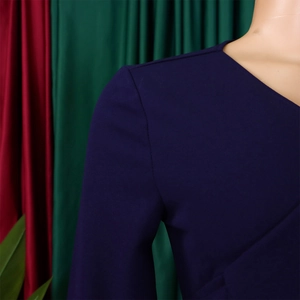 Détail d'une robe bleu foncé avec col en V, texture en polyester et coutures soignées