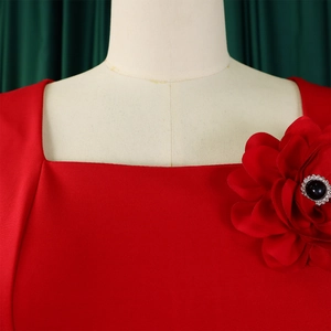 Detail of red square neck dress featuring a large 3D flower with black gemstone and rhinestones