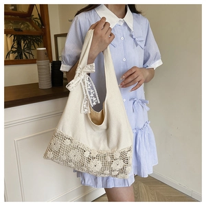 Detail of canvas tote bag featuring large crochet floral lace and bow decoration