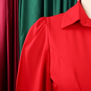 Detail of red satin shirt with puff sleeves and sharp collar on a mannequin