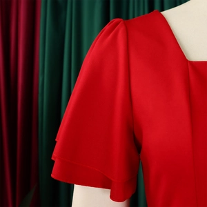 Close-up of red square neck dress featuring tiered ruffle sleeves and premium fabric