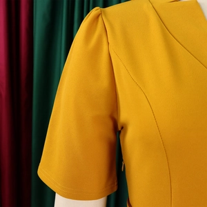Détail de robe jaune montrant les épaules plissées et la fermeture éclair invisible